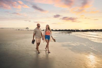 couple walking at sunrise along south beach
