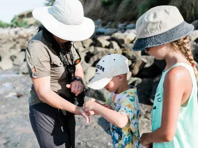 Family exploring the shoreline during a fossil hunting tour with Sundial Charters.
