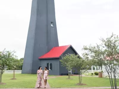 Two women walking the grounds of a lighthouse.